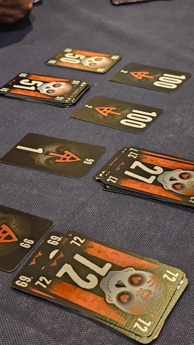 The Game + The Game on Fire on the table, photo by Jugar y Leer