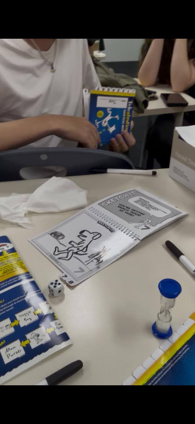 Telestrations: 12 Player Party Pack on the table, photo by Paige